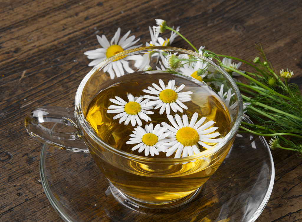 glass cup of camomile tea on a wooden table